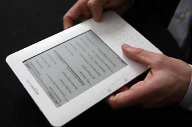 In this 2009 file photo, the Kindle 2 electronic reader is shown at an Amazon.com news conference in New York. Despite eliminating many costs associated with regular books, e-books are often more expensive than paperbacks.